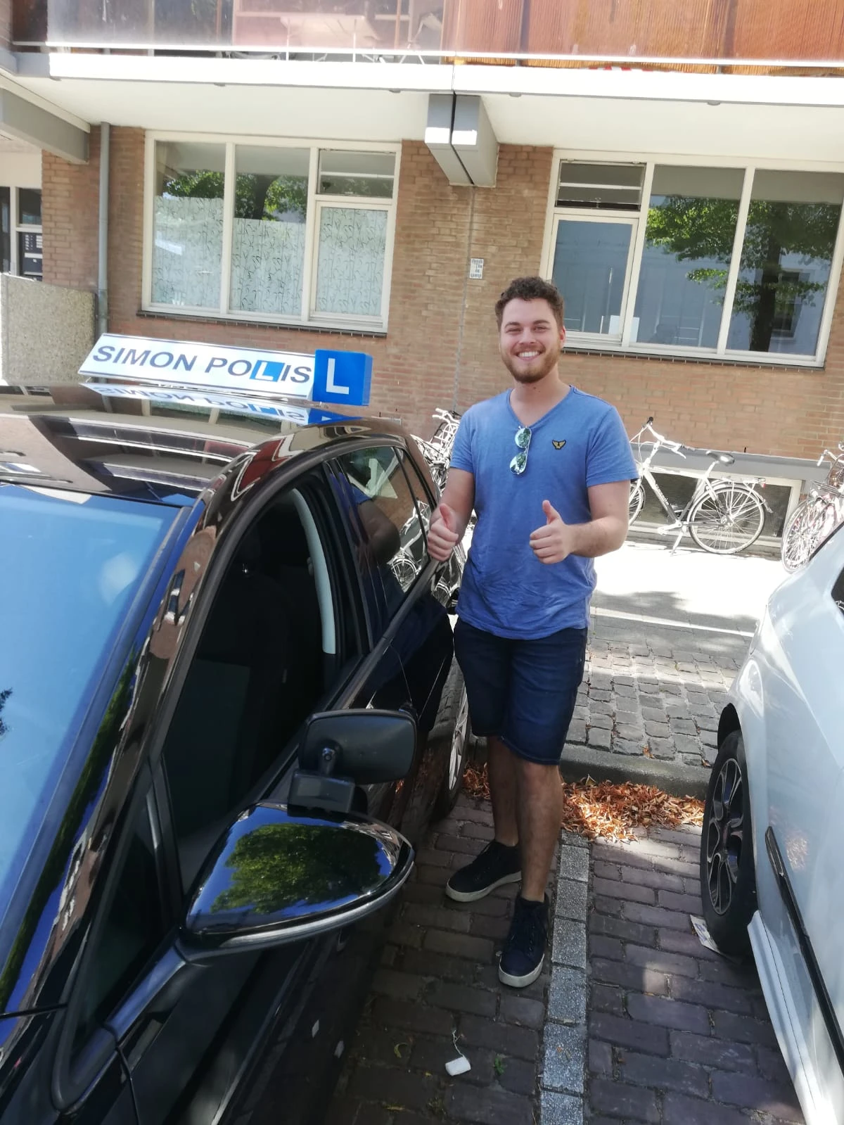 Geslaagde leerling bij lesauto